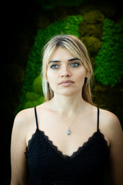 tree of life crystal pendant with cremation ash being worn by blond woman